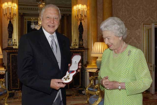 Britain's Queen Elizabeth II presents TV naturalist Sir David Attenborough with the Insignia of the Order of Merit, a personal award from the Queen recognising exceptional achievements in the advancement of arts, learning, literature and science at Buckingham Palace in London, 10 June, 2005. AFP PHOTO/FIONA HANSON/WPA POOL/PA (Photo by FIONA HANSON / POOL / AFP) (Photo by FIONA HANSON/POOL/AFP via Getty Images)