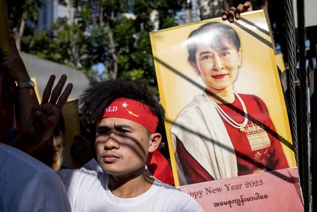 A Burmese protester gives a three-figure salute beside a picture of detained Myanmar civilian leader Aung San Suu Kyi during a demonstration outside the Embassy of Myanmar in Bangkok. Credit: JACK TAYLOR/AFP via Getty Images