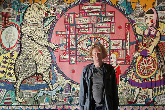Grayson Perry stands in front of his tapestry ‘Map of Truths and Beliefs’ at The Tomb of the Unknown Craftsman exhibition at the British Museum on October 5, 2011. Credit: Peter Macdiarmid/Getty Images