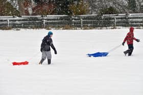 COUPAR ANGUS, UNITED KINGDOM - JANUARY 22:  Children pull sledges through the snow  in Coupar Angus on January 22, 2013 in Coupar Angus, United Kingdom.  (Photo by Jeff J Mitchell/Getty Images)
