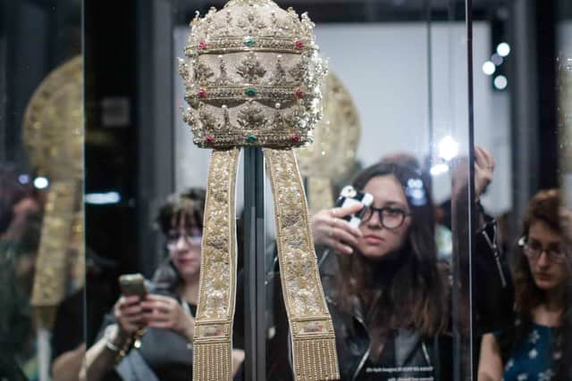 Members of the media look at Papal Tiaras from the Sistine Chapel (AFP via Getty Images)