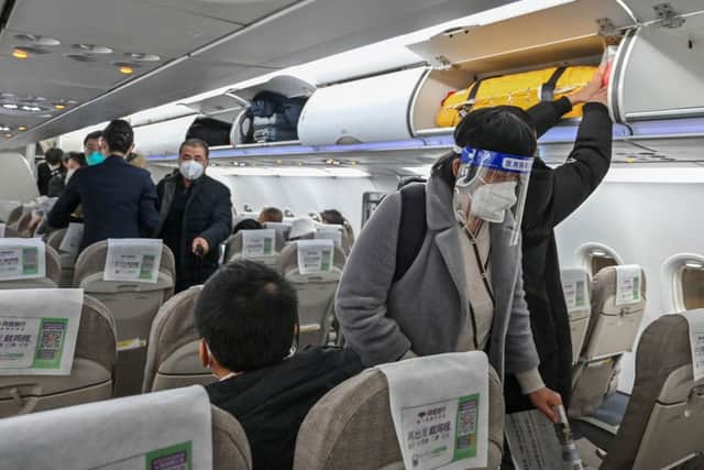 A passenger wearing a face shield and mask boards a domestic flight at Shanghai Pudong International Airport in Shanghai on January 3, 2023. Credit: Getty Images