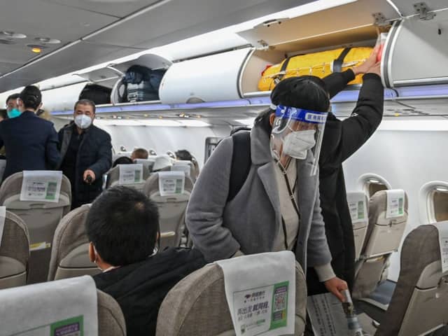 A passenger wearing a face shield and mask boards a domestic flight at Shanghai Pudong International Airport in Shanghai on January 3, 2023. Credit: Getty Images