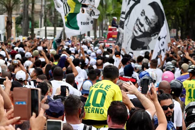 People follow the funeral procession of Brazilian football legend Pele as his coffin is transported through the streets of Santos (Getty Images)