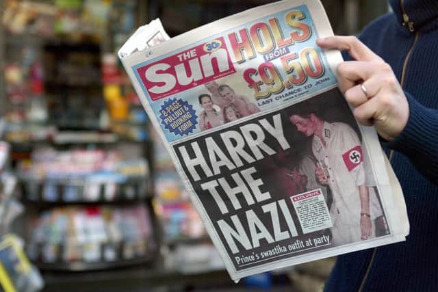   A man reads the British tabloid The Sun featuring Harry on the front page (Photo: AFP via Getty Images)