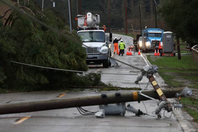 Utility workers prepare to make repairs to downed power lines on Nicasio Valley Road after utility poles were toppled by high winds on January 05, 2023 in Nicasio, California. Credit: Justin Sullivan/Getty Images