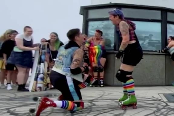 Video grab as a couple unknowingly planned the same surprise engagement for each other on the same day - and even had identical ring boxes.  Flint and Sarah-Jean, who did not want their surnames revealed, proposed to each other while roller skating. See SWNS story SWSMproposal.  Video shows the couple skating along the sunny California coastline with their roller derby team before Flint, 32, gets down on one knee and proposes to Sarah-Jean, 34.  Then Sarah-Jean, a documentary photographer, does the same and proposes to Flint with the exact same ring box. The couple, who lives in Orange County, California, USA, had both independently planned the same secret engagement on their favourite route to skate with their roller derby team. The route ran along Long Beach, ending at the Lion Lighthouse, and both had secretly invited all their friends and family and hired a photographer each.