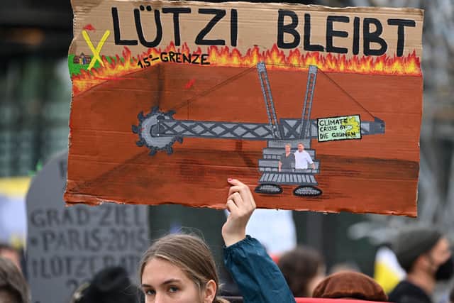 A demontrator holds a sign against the demolition of the village of Luetzerath at the Garzweiler open-cast lignite mine during a demonstration before the party congress of the Greens at the World Conference Center in Bonn, western Germany on October 14, 2022. - The first party conference of the Greens to be held “in person” in three years, will take place on 15-16 October, and will focus in particular on nuclear power plant lifespans and the planned support in the face of rising energy prices. (Photo by Ina FASSBENDER / AFP) (Photo by INA FASSBENDER/AFP via Getty Images)