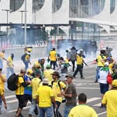 Supporters of Brazilian former President Jair Bolsonaro clash with the police during a demonstration outside the Planalto Palace in Brasilia on January 8, 2023. - Brazilian police used tear gas Sunday to repel hundreds of supporters of far-right ex-president Jair Bolsonaro after they stormed onto Congress grounds one week after President Luis Inacio Lula da Silva's inauguration, an AFP photographer witnessed. (Photo by EVARISTO SA / AFP) (Photo by EVARISTO SA/AFP via Getty Images)