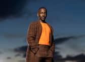 Ncuti Gatwa as the Fifteenth Doctor in Doctor Who, wearing a brown patterned coat over a bright orange cropped jumper (Credit: BBC/Bad Wolf/James Pardon)