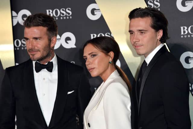 Victoria Beckham with husband David and oldest son Brookly. Despite Victoria's company losing money, their overall empire has reportedly doubled its profits.  (Photo by Jeff Spicer/Getty Images)