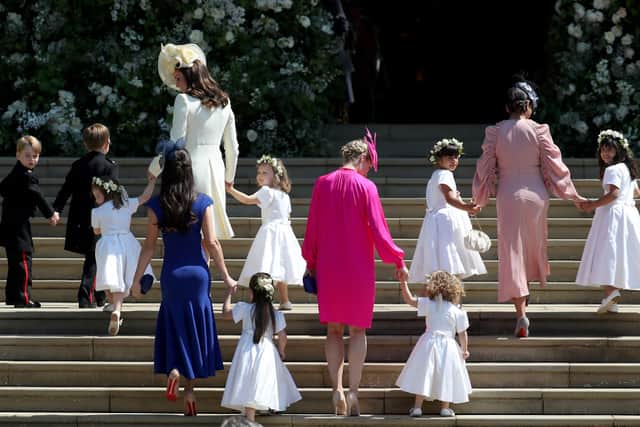 The dresses at the centre of the disagreement between Meghan and Kate. Prince George of Cambridge, Jasper Dyer, Princess Charlotte of Cambridge, Catherine, Duchess of Cambridge, Jessica Mulroney, Ivy Mulroney, Florence van Cutsem, Zoe Warren, Zalie Warren, Benita Litt, Remy Litt and Rylan Litt arrive at the wedding of Prince Harry and Ms. Meghan Markle at St George's Chapel at Windsor Castle on May 19, 2018 in Windsor, England. (Photo by Jane Barlow - WPA Pool/Getty Images)
