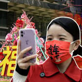 Girl holds phone with face mask on celebrating Chinese New Year (Getty Images)