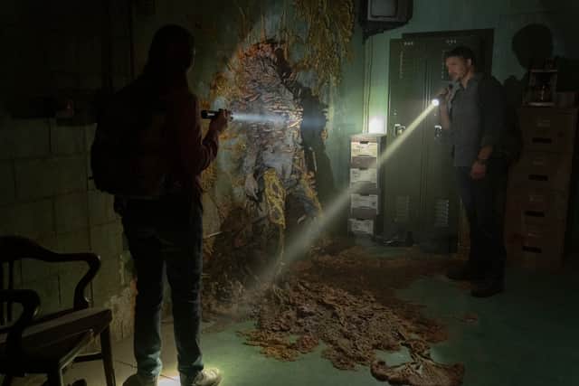 Pedro Pascal as Joel in The Last of us, inspecting a cordyceps infected victim (Credit: HBO/Warner Media/Liane Hentscher)