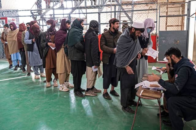 Afghans stand in a queue as they wait to receive food aid from a non-governmental organisation at a gymnasium in Kabul on January 17, 2023. Credit: Getty Images