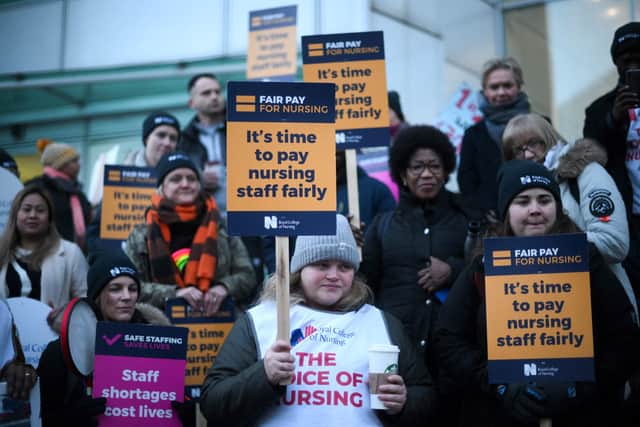 Striking nurses hold signs at a picket line outside University College Hospital in London on January 19, 2023. - Nurses across England are staging two days of strikes over pay, threatening fresh disruption for patients in the creaking state-run health service, as new figures showed inflation still surging. The 48-hour walkout comes after nurses held their union's first stoppage in over a century last month, joining a wave of industrial action by UK public sector workers hit by a cost-of-living crisis driven by spiralling prices. (Photo by Daniel LEAL / AFP) (Photo by DANIEL LEAL/AFP via Getty Images)
