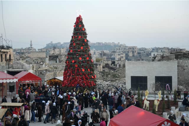 Syrians gather in a Christmas market in at al-Hatab square in Syria's northern city of Aleppo on December 24, 2022. (Photo by AFP) (Photo by -/AFP via Getty Images)