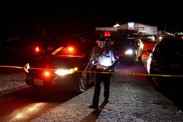 A San Mateo County sheriff deputy walks towards police tape as law enforcement officials conduct an investigation following a mass shooting on January 23, 2023 in Half Moon Bay, California