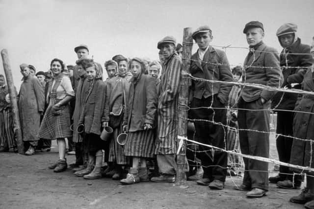 April 1945:  Starving internees at Belsen concentration camp waiting at the cook house gate for their rations of potato soup. 
