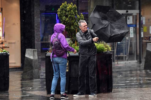 Pedestrians struggle against the wind in Glasgow city centre on August 25, 2020, as Storm Francis brings rain and high winds to the UK.  (Photo by ANDY BUCHANAN/AFP via Getty Images)