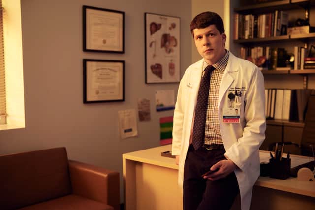 Jesse Eisenberg as Toby Fleishman in Fleishman is in Trouble, wearing a white doctor’s coat and stood in his office (Credit: Matthias Clamer/FX)