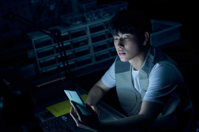 Yim Si-wan as Jun-yeong in Unlocked, sitting in the dark illuminated by the glow of the phonescreen (Credit: Netflix)