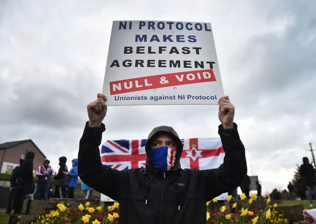 Loyalists hold up placards during an anti Northern Ireland Protocol protest against the so called Irish Sea border on April 6, 2021 in Larne, Northern Ireland. Credit: Getty Images