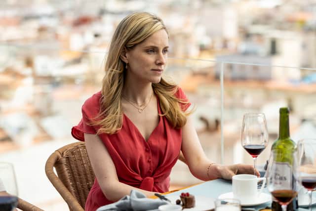 Sophie Rundle as Laura Simmonds in The Diplomat, drinking wine with dinner on a balcony (Credit: UKTV)