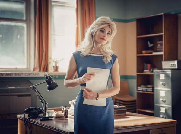Gemma Arterton stars as Barbara Parker in Funny Woman, stood in an office hlding pages of a screenplay (Credit: Sky)