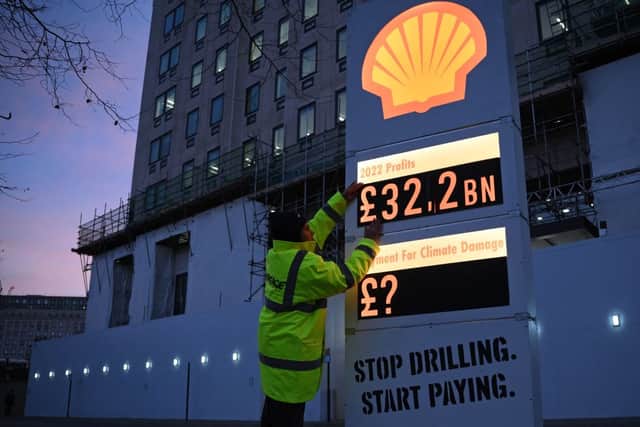 Activists from Greenpeace set up a mock-petrol station price board displaying the Shell’s net profit for 2022, as they demonstrate outside the company’s headquarters in London on February 2, 2023, as the British energy company announce their full-year results (Photo by DANIEL LEAL/AFP via Getty Images)