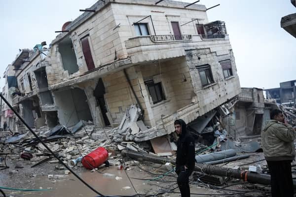 Residents stand in front of a collapsed building following an earthquake in the town of Jandaris (Photo: Getty Images)