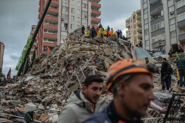Rescuers search for victims and survivors amidst the rubble of a building that collapsed in Adana on February 6, 2023, after a 7.8-magnitude earthquake struck the country’s south-east (Photo by CAN EROK/AFP via Getty Images)