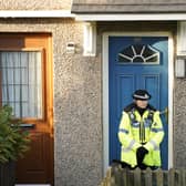 A police officer stands outside a property in Walpole Road, Huddersfield, West Yorkshire, where a woman was arrested on suspicion of attempted murder, after four people, including three children, were found seriously injured. Credit: PA