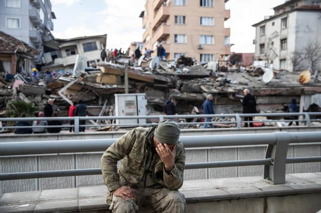 A soldier sits devastated near a collapsed building in Hatay, Turkey (Image: Getty)