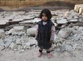 A Syrian girl stands among the rubble caused by two earthquakes (image: AFP/Getty Images)