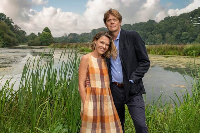 Sally Bretton as Martha Lloyd and Kris Marshall as Humphrey Goodman in Beyond Paradise, stood in front of a lake and some tall grass (Credit: BBC One/Red Planet Pictures)