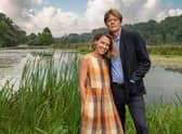Sally Bretton as Martha Lloyd and Kris Marshall as Humphrey Goodman in Beyond Paradise, stood in front of a lake and some tall grass (Credit: BBC One/Red Planet Pictures)