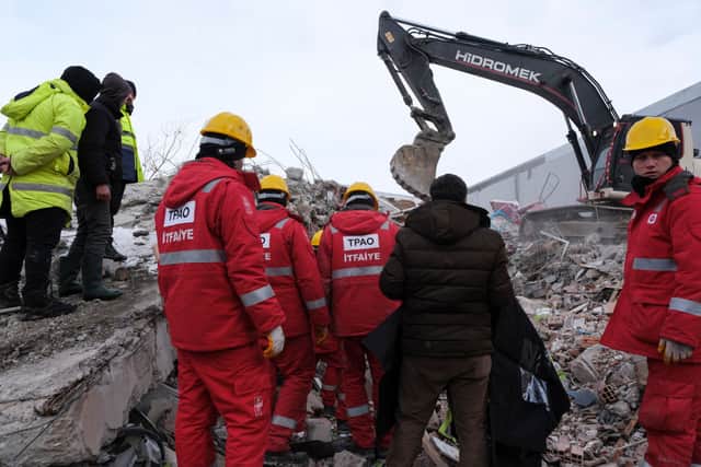 Local people, rescue volunteers and firemen search the rubble during rescue operations (Photo: Getty Images)
