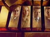 Hugh Bonneville as Brian Boyce, Charlotte Spencer as Nikki Jennings, Dominic Cooper as Edwyn Cooper, Jack Lowden as Kenneth Noye, and Tom Cullen as John Palmer in The Gold, their faces reflected in bars of gold (Credit: BBC/Tannadice Pictures/Sally Mais)
