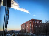 A meteorite trail is seen above a residential apartment block in the city of Chelyabinsk (Photo: -/74.RU/AFP via Getty Images)