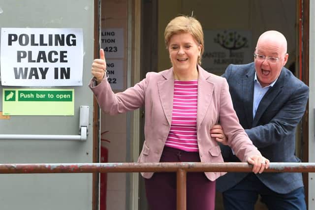 Scotland's First Minister and Scottish National Party (SNP) leader Nicola Sturgeon reacts as she is surprised by her husband and current chief executive officer of the Scottish National Party Peter Murrell, after casting their vote in local elections, at a polling station, in Glasgow, on May 5, 2022. Photo by ANDY BUCHANAN / AFP) (Photo by ANDY BUCHANAN/AFP via Getty Images