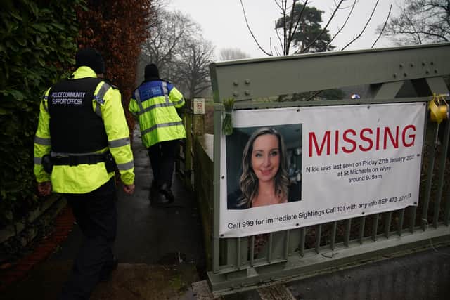 Police officers walk past a missing person appeal poster for Nicola Bulley tied to a bridge over the River Wyre in St Michael’s on Wyre, Lancashire. Credit: PA