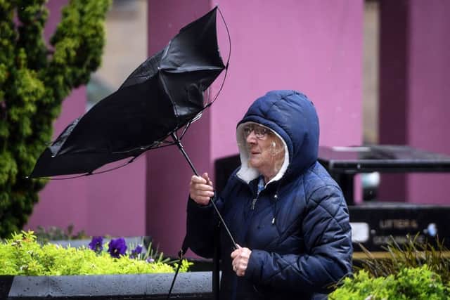 A pedestrian struggles with her umbrella against the wind in Glasgow city centre on August 25, 2020, as Storm Francis brings rain and high winds to the UK. (Photo by ANDY BUCHANAN/AFP via Getty Images)