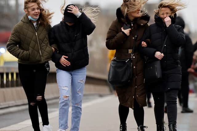 People struggle in the wind as they walk across Westminster Bridge, in central London, on February 18, 2022, as Storm Eunice brings high winds across the country. (Photo by TOLGA AKMEN/AFP via Getty Images)