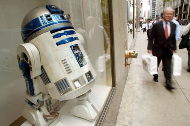 A man walks past full size R2-D2 Star Wars movie prop in the Sharper Image store window May 17, 2002 in New York City (Credit: Mario Tama/Getty Images)