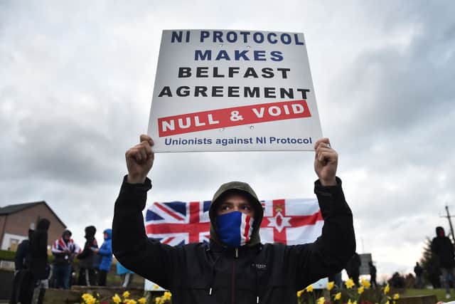 Loyalists hold up placards during an anti Northern Ireland Protocol protest against the so-called Irish Sea border on April 6, 2021 in Larne, Northern Ireland. Credit: Getty Images