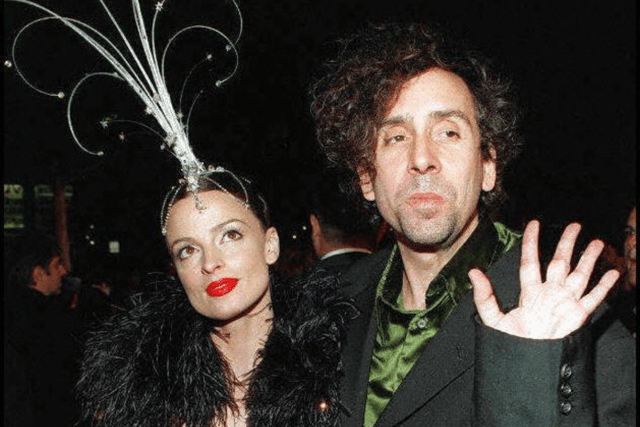 Director Tim Burton waves as he arrives with “friend” Lisa Marie for the premiere of his new film, Mars Attacks. (Credit: Getty Images)