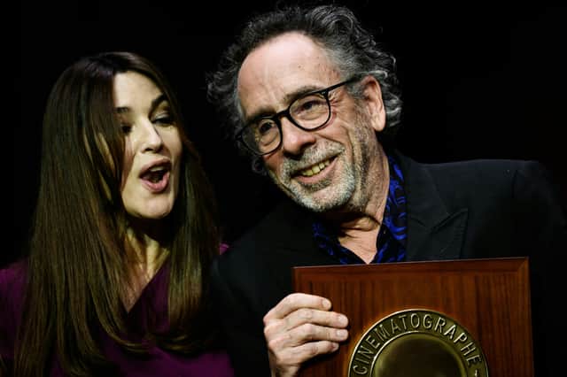 US director Tim Burton (R) receives the Lumiere Award from Italian actress Monica Bellucci during the award ceremony of the 14th edition of the Lumiere Film Festival in Lyon, central-eastern France, on October 21, 2022