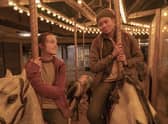Bella Ramsey as Ellie Williams & Storm Reid as Riley Abel in The Last of Us, on a roundabout carousel (Credit: HBO)