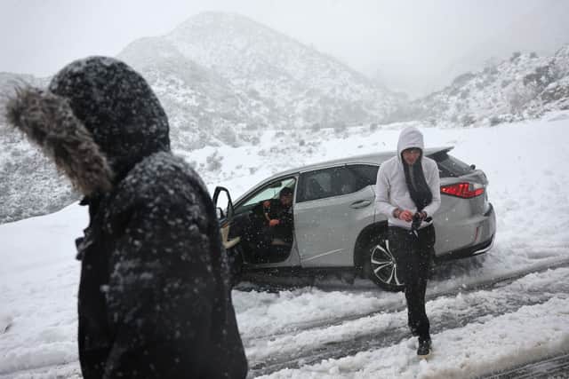 Car stuck in the snow on a roadway in Los Angeles County, in the San Gabriel Mountains in Angeles National Forest, on February 24, 2023. (Photo by Mario Tama/Getty Images)